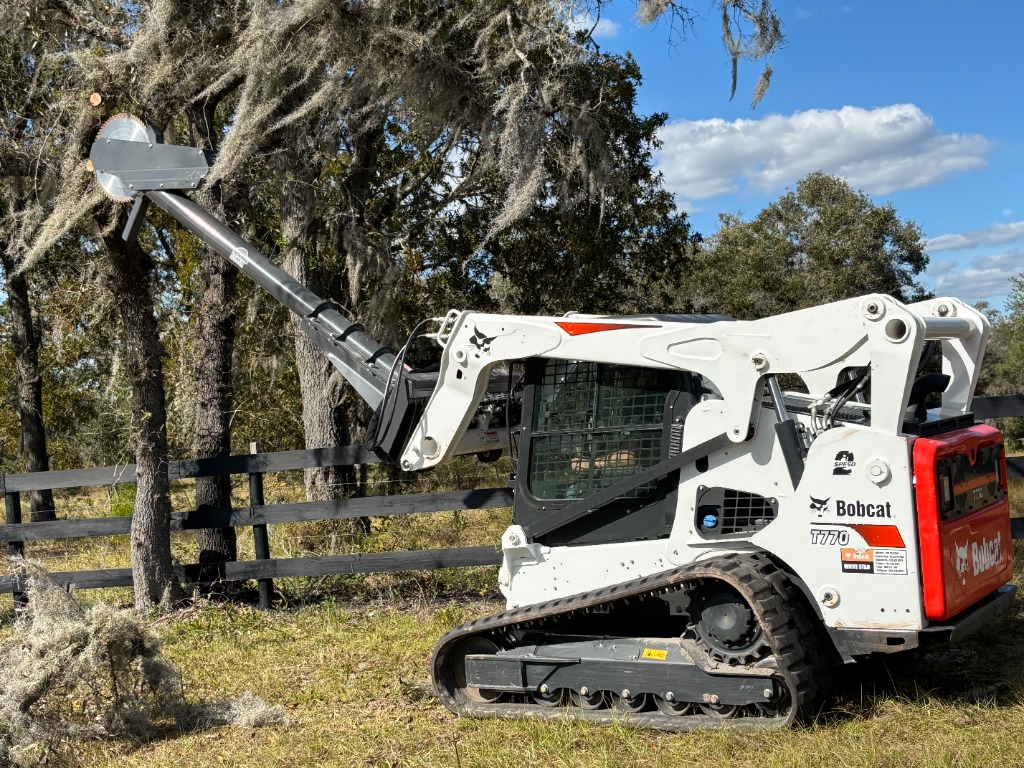 Bobcat skid steer with high-limb saw attachment