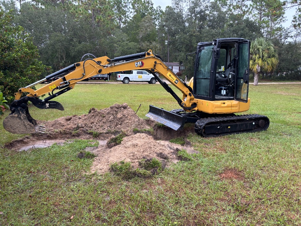 CAT mini excavator digging on site